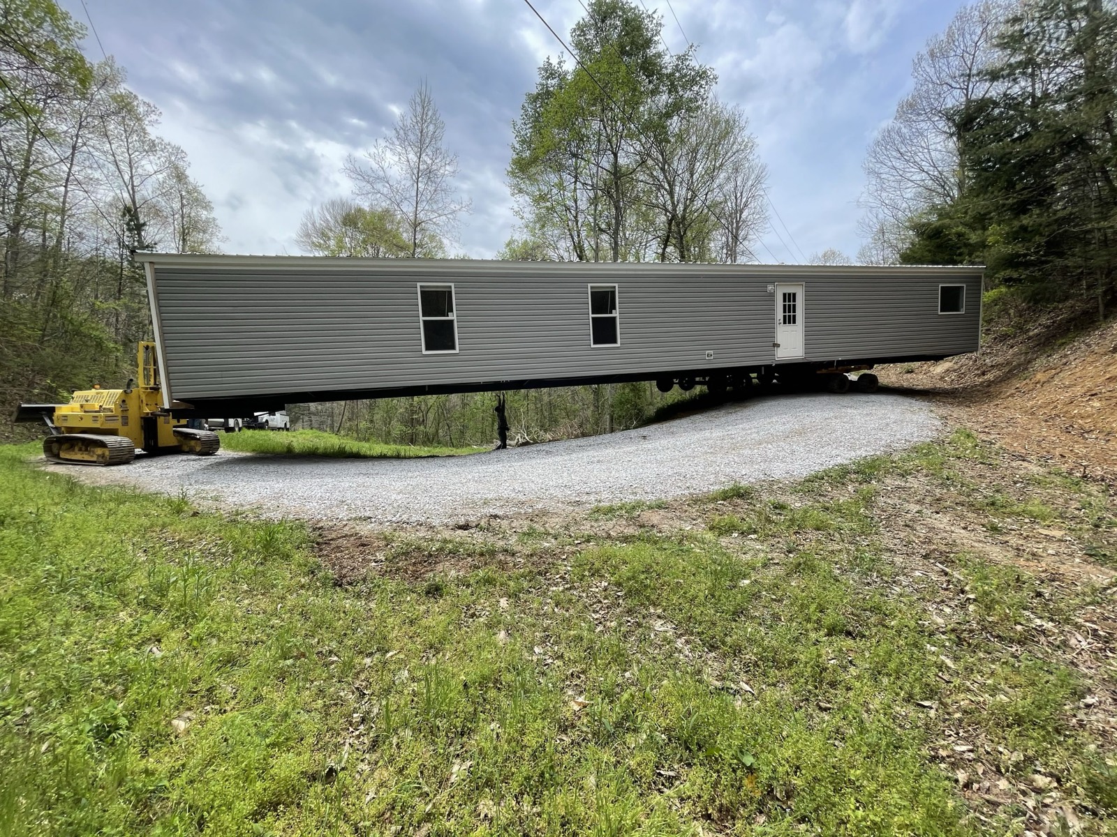 A compacted gravel building pad on a wooded lot